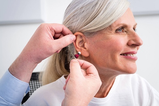 Ältere Frau erhält Hörgerät-Anpassung beim Akustiker für besseres Hören und Lebensqualität.